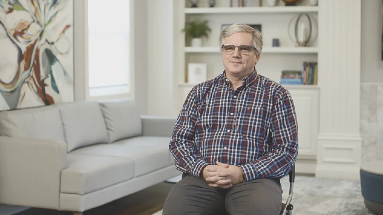 Photo of Kent Guthrie smiling at the camera in a living room
