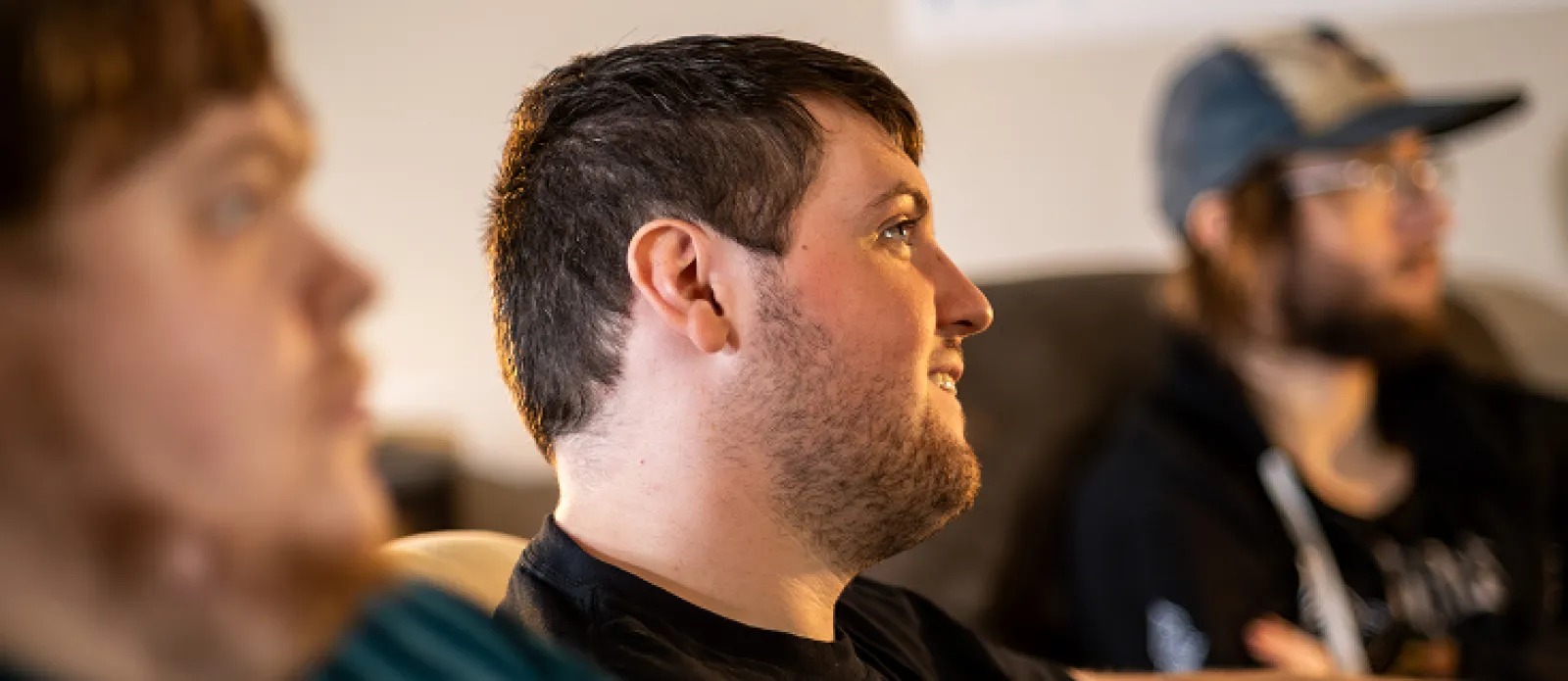 Three LifeWorks participants watching a moving in an apartment socializing.